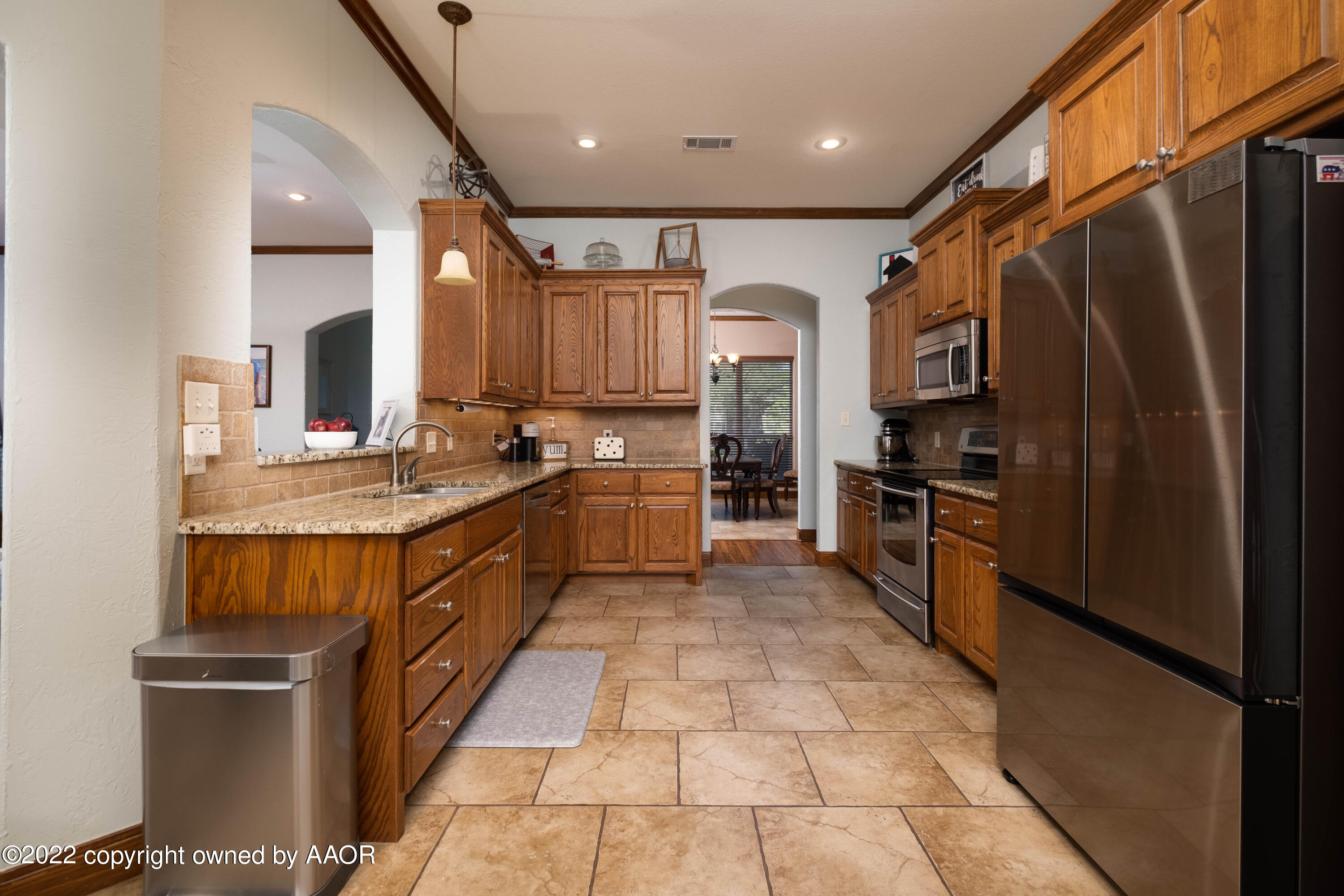 8417 Hamilton Drive Amarillo, TX 79119 - Photo 13 of 42 a large kitchen with stainless steel appliances kitchen island granite countertop a stove refrigerator and cabinets
