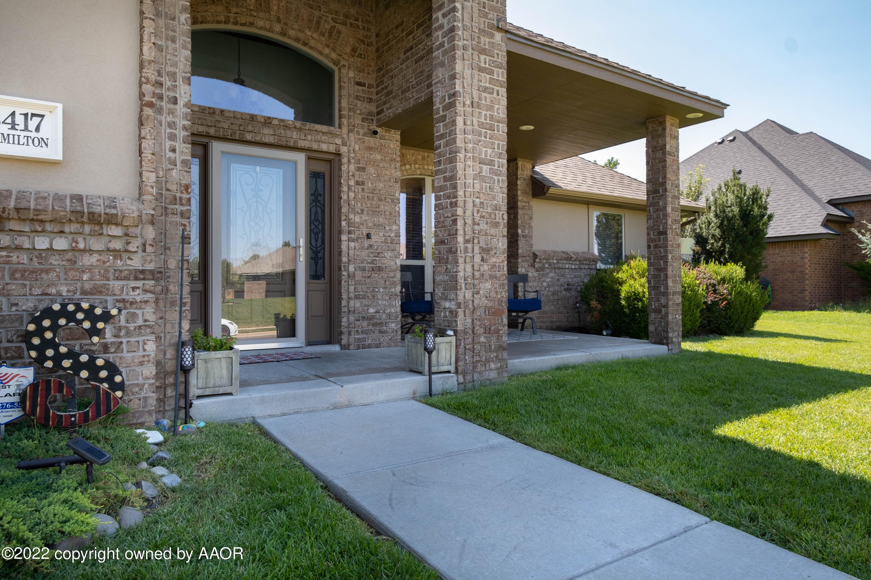 8417 Hamilton Drive Amarillo, TX 79119 - Photo 4 of 42 a view of a house with brick walls and a yard with plants