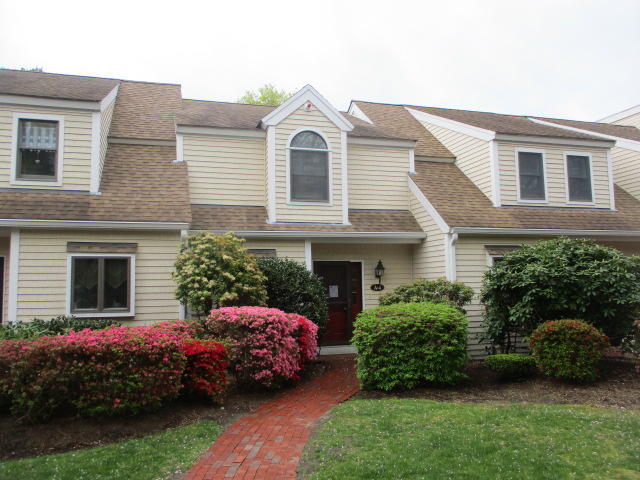 4 Shellback Way, Unit A Mashpee, MA 02649 - Photo 1 of 16 a front view of a house with a garden and plants