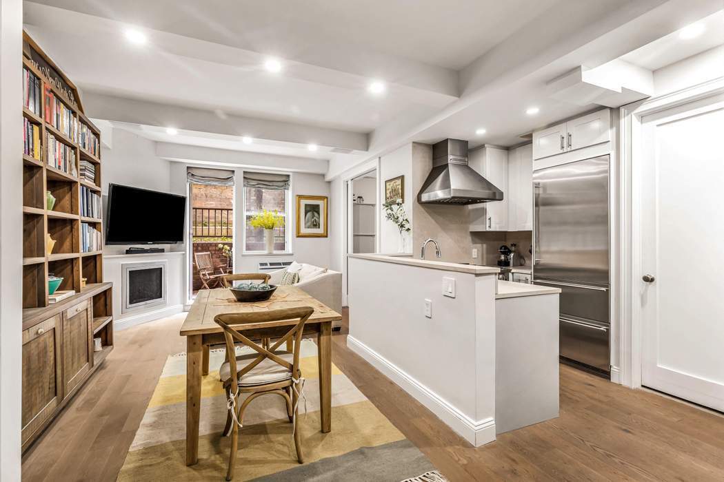 a kitchen with stainless steel appliances granite countertop a stove refrigerator and a flat screen tv
