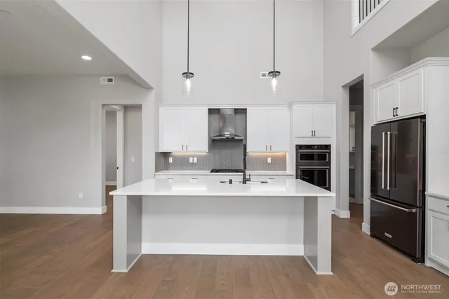 a large kitchen with kitchen island stainless steel appliances cabinets a sink and a counter top space