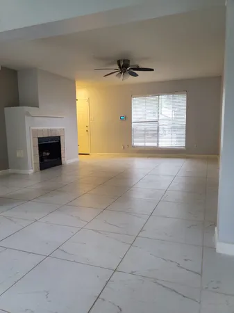 an empty room with windows and fireplace