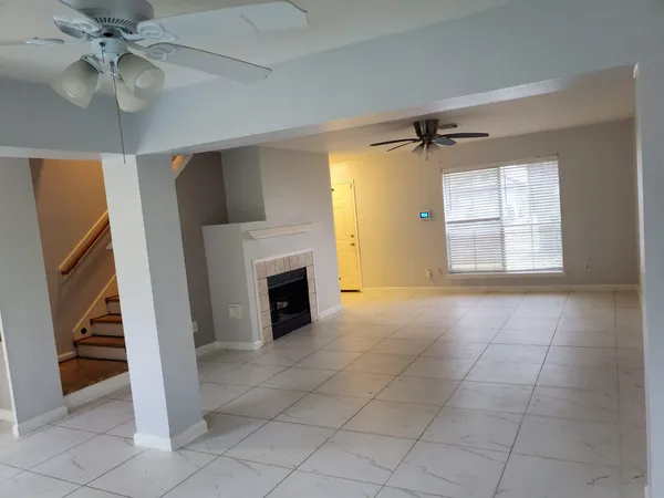 a view of an empty room with a fireplace and a window