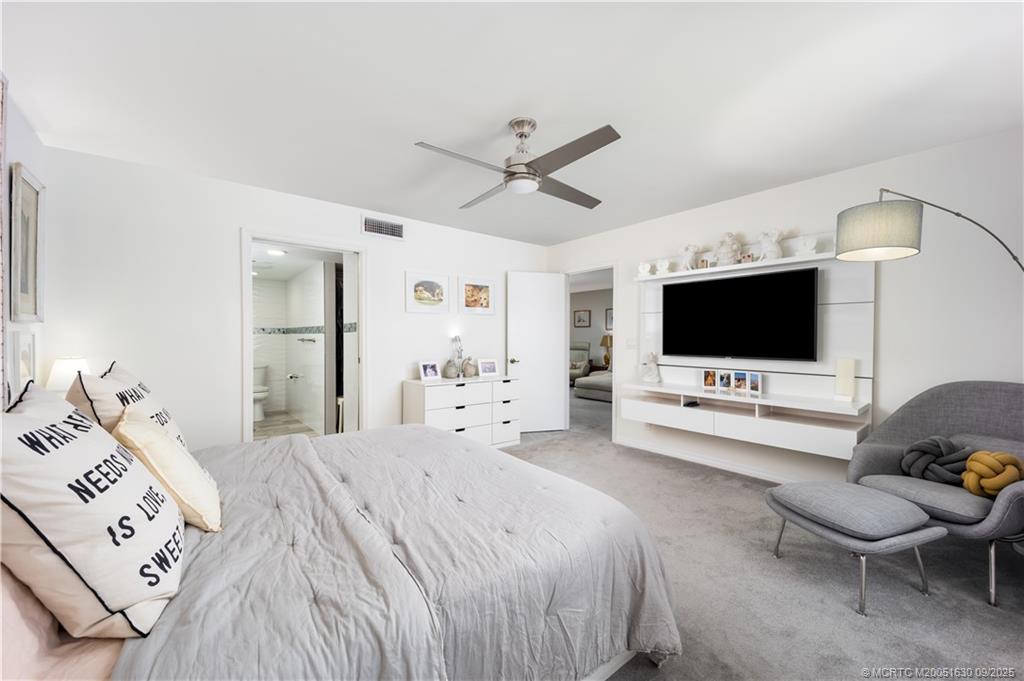 3100 Southeast Pruitt Road, Unit E204 Port St. Lucie, FL 34952 - Photo 13 of 40 a bedroom with a bed and a flat screen tv