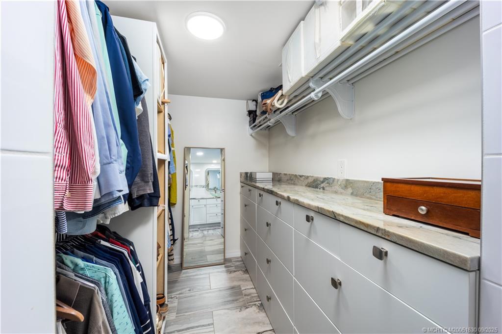 3100 Southeast Pruitt Road, Unit E204 Port St. Lucie, FL 34952 - Photo 15 of 40 a view of walk in closet with clothes and shoes