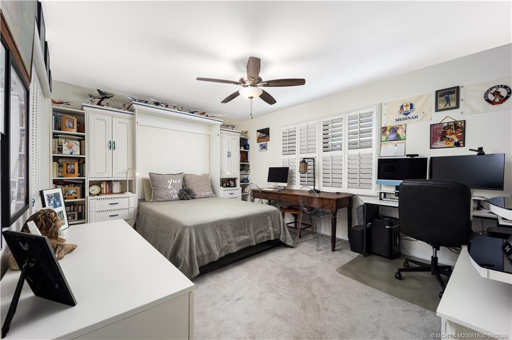 3100 Southeast Pruitt Road, Unit E204 Port St. Lucie, FL 34952 - Photo 17 of 40 a bedroom with a bed work place view and a desk