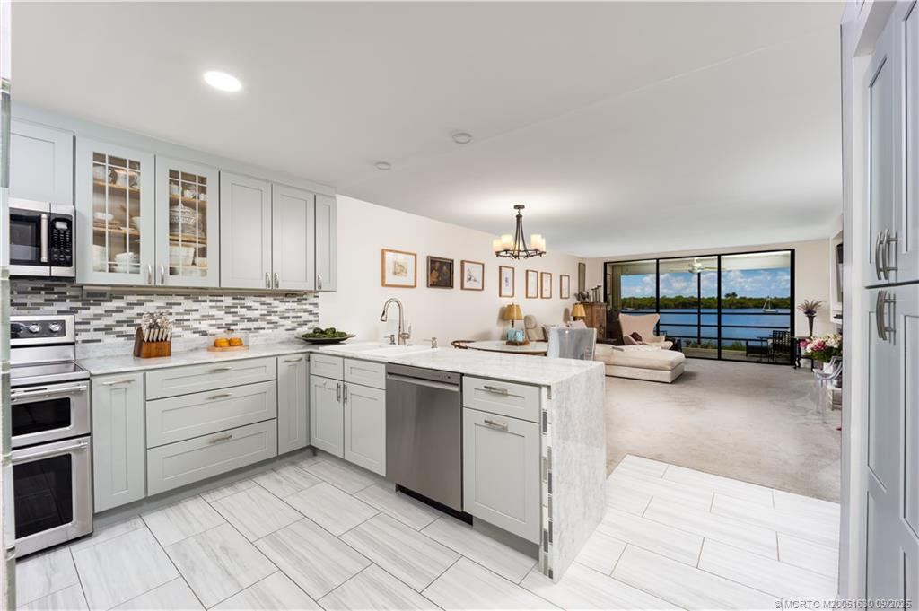 3100 Southeast Pruitt Road, Unit E204 Port St. Lucie, FL 34952 - Photo 6 of 40 a kitchen with sink cabinets and stove top oven