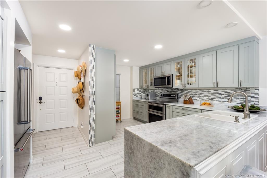 3100 Southeast Pruitt Road, Unit E204 Port St. Lucie, FL 34952 - Photo 7 of 40 a kitchen with stainless steel appliances granite countertop a refrigerator and a stove top oven
