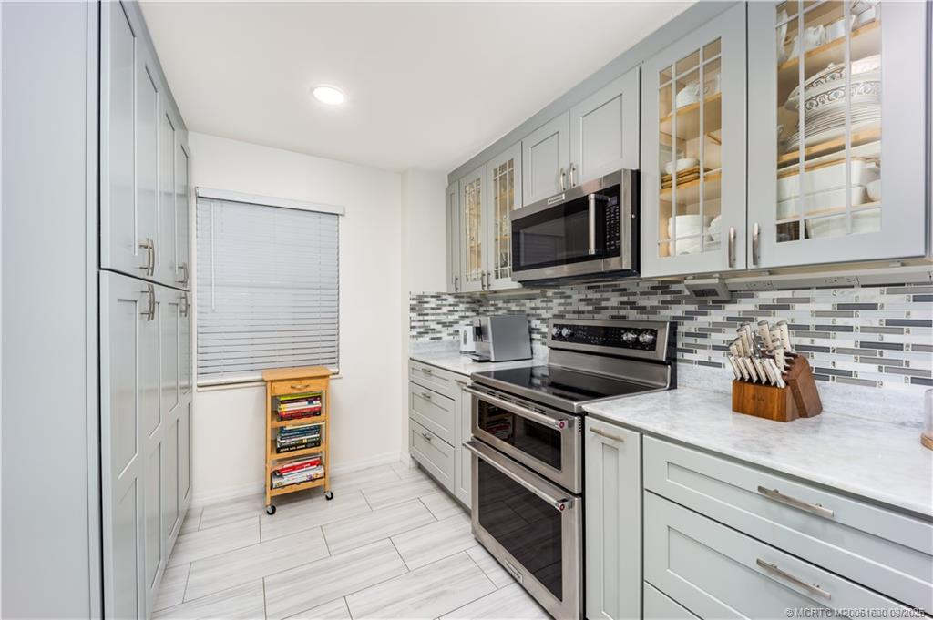 3100 Southeast Pruitt Road, Unit E204 Port St. Lucie, FL 34952 - Photo 8 of 40 a kitchen with stainless steel appliances a stove microwave and cabinets