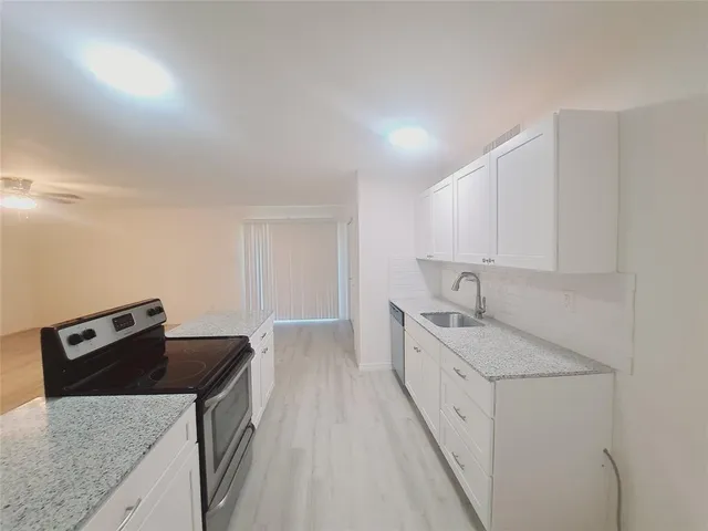 a kitchen with a sink stove and cabinets