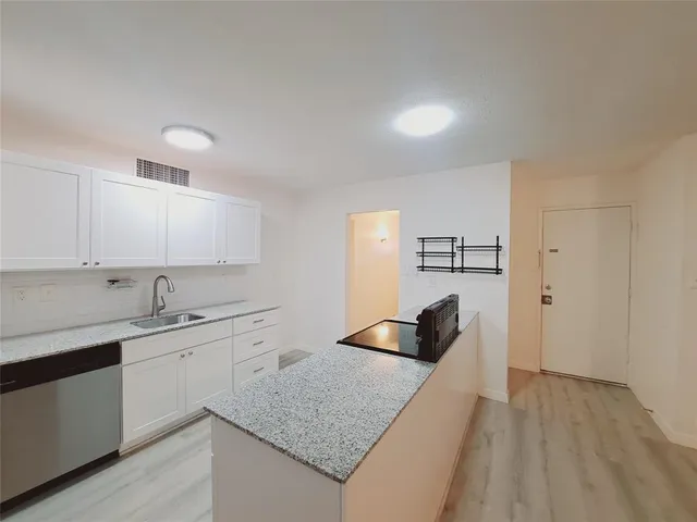 a kitchen with a sink dishwasher and cabinets