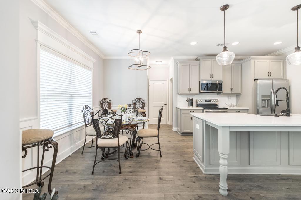 129 Timber Ridge Circle Byron, GA 31008 - Photo 13 of 42 a dining room filled chandelier and kitchen view