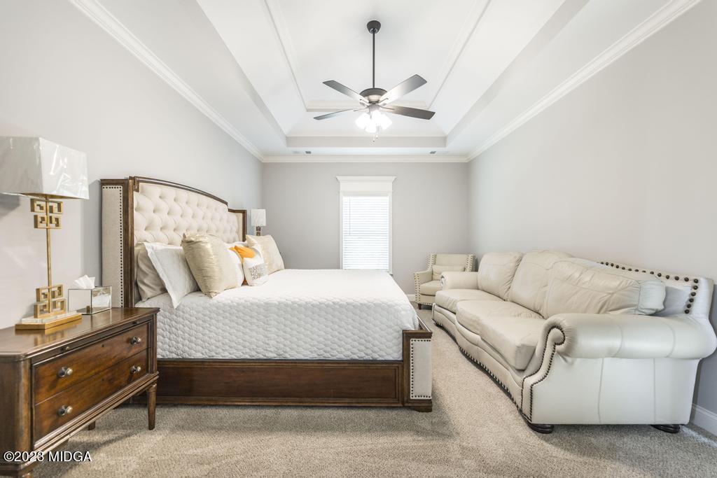 129 Timber Ridge Circle Byron, GA 31008 - Photo 24 of 42 a bedroom with a large bed couch and chandelier