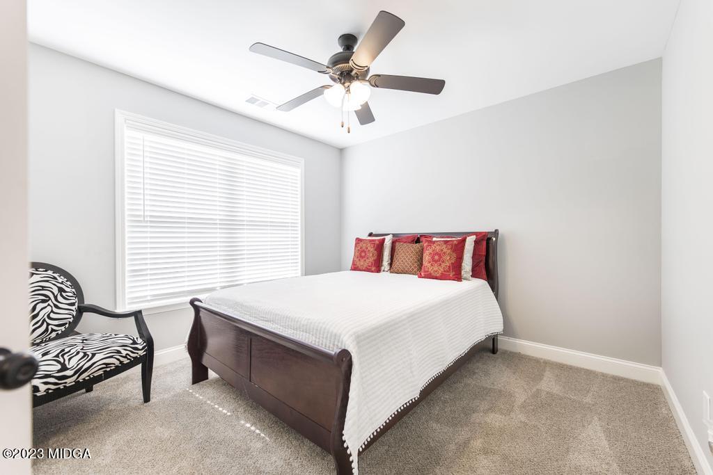 129 Timber Ridge Circle Byron, GA 31008 - Photo 31 of 42 a bedroom with a bed and a chandelier