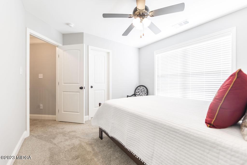 129 Timber Ridge Circle Byron, GA 31008 - Photo 32 of 42 a bedroom with a bed and a chandelier