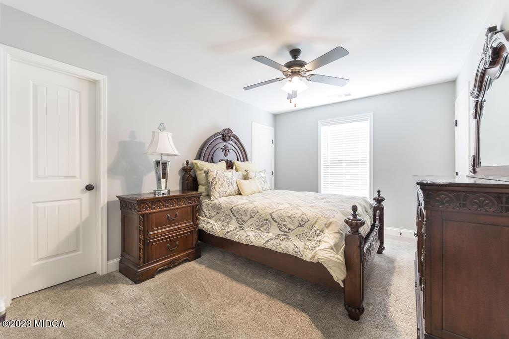 129 Timber Ridge Circle Byron, GA 31008 - Photo 34 of 42 a bedroom with a bed and a chandelier