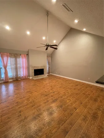 an empty room with windows and fireplace