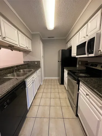 a kitchen with stainless steel appliances granite countertop a stove and a microwave