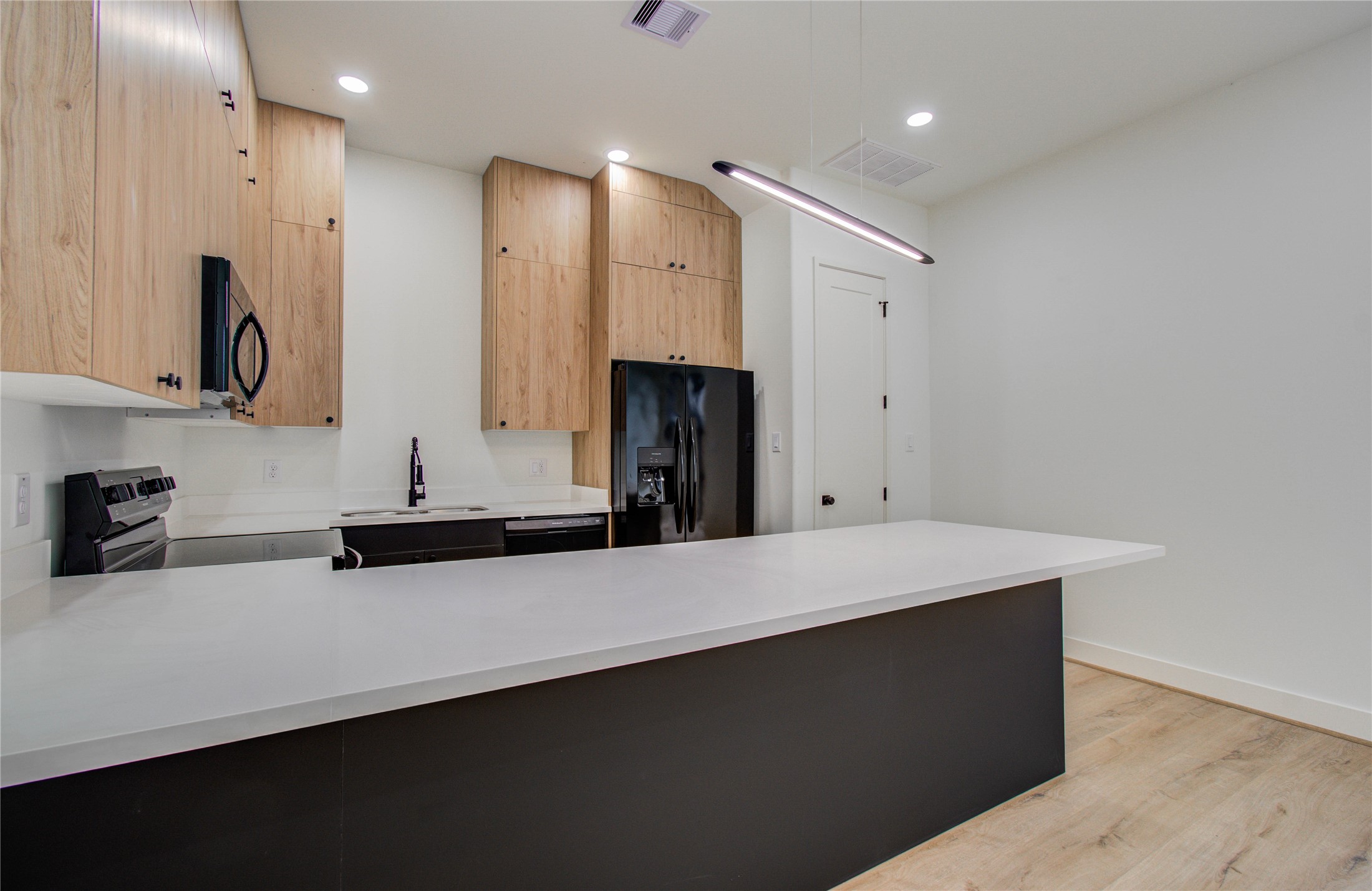 1815 McKee Street, Unit 1 Houston, TX 77009 - Photo 15 of 25 a kitchen with a sink a large mirror and refrigerator