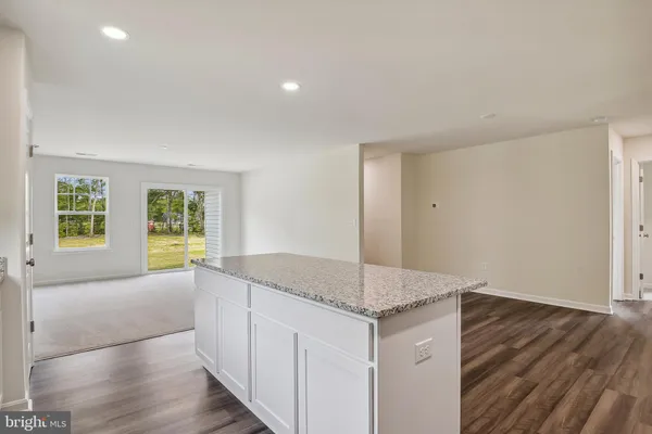 a large kitchen with kitchen island granite countertop a large counter top and stainless steel appliances
