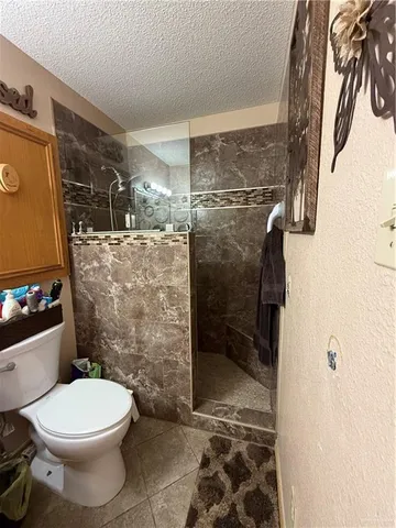 a kitchen with stainless steel appliances granite countertop a refrigerator a stove a sink dishwasher and a dining table with wooden floor