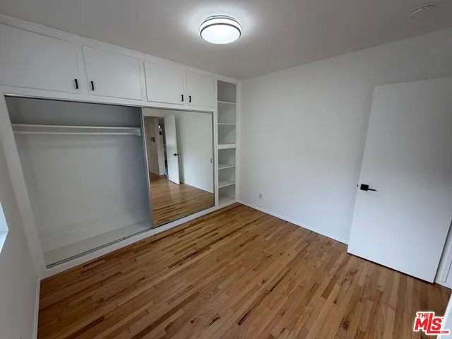 a view of a room with wooden floor and cabinets