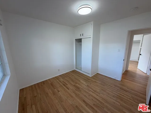 an empty room with wooden floor and entrance