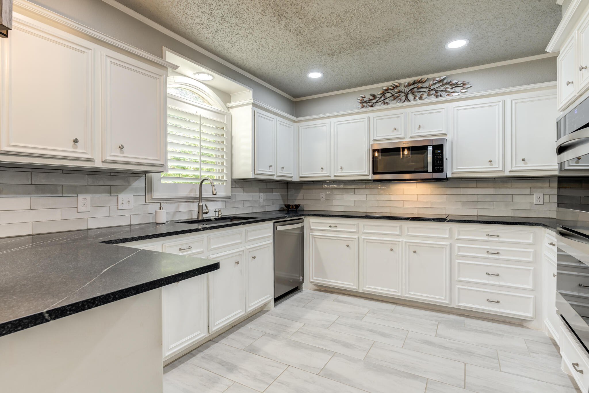 8204 Colton Avenue Lubbock, TX 79424 - Photo 2 of 19 a kitchen with cabinets appliances a sink and a window