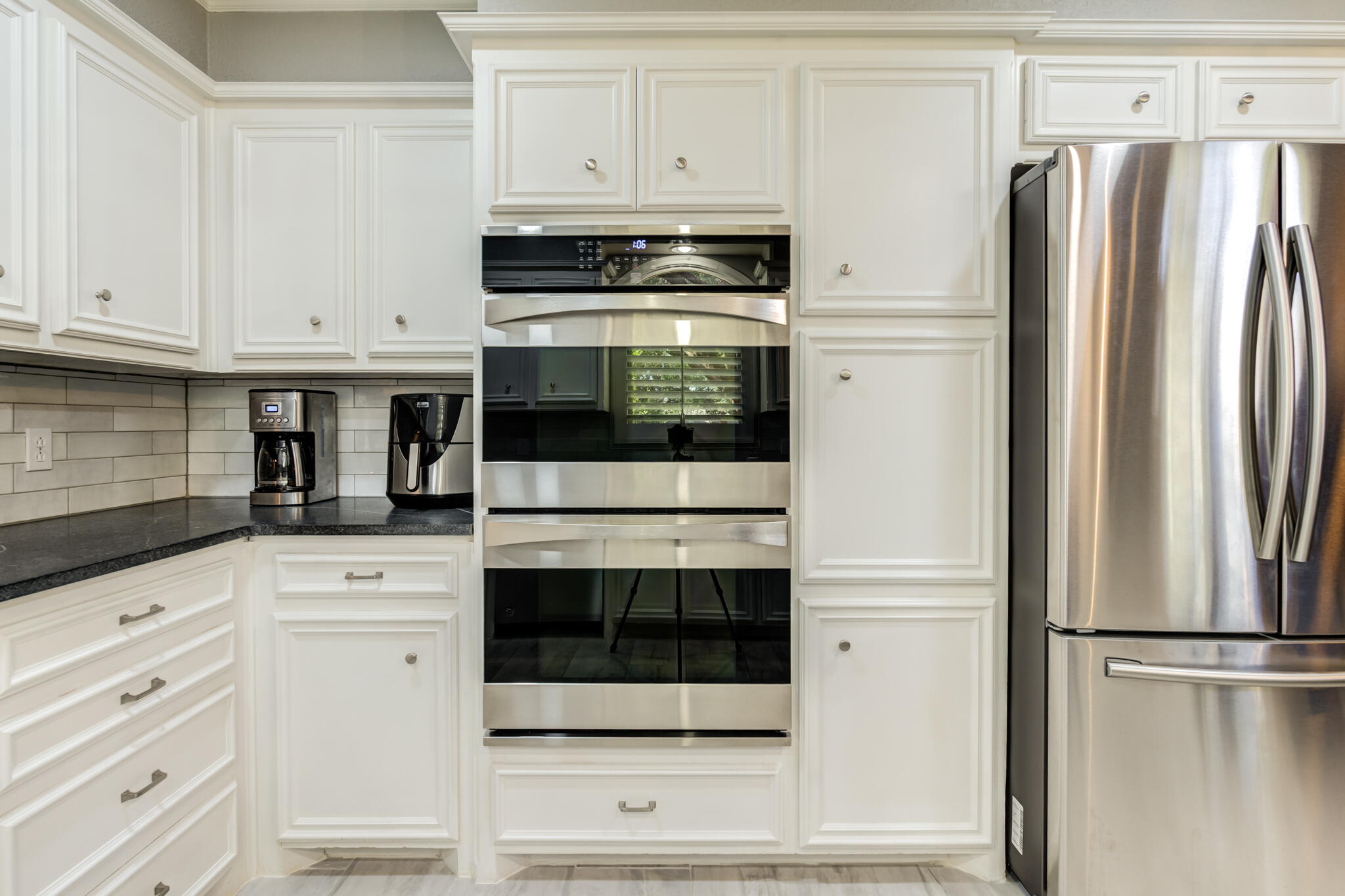 8204 Colton Avenue Lubbock, TX 79424 - Photo 3 of 19 a kitchen with stainless steel appliances white cabinets and white appliances