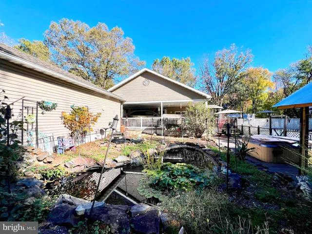 a view of a patio with table and chairs potted plants and large tree
