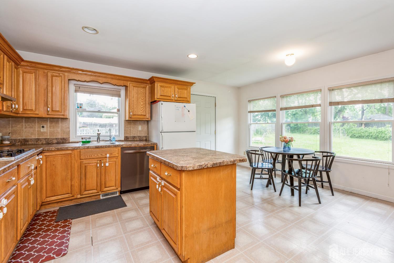 8 Longfellow Drive Colonia, NJ 07067 - Photo 6 of 24 a kitchen with stainless steel appliances granite countertop sink stove top oven and cabinets