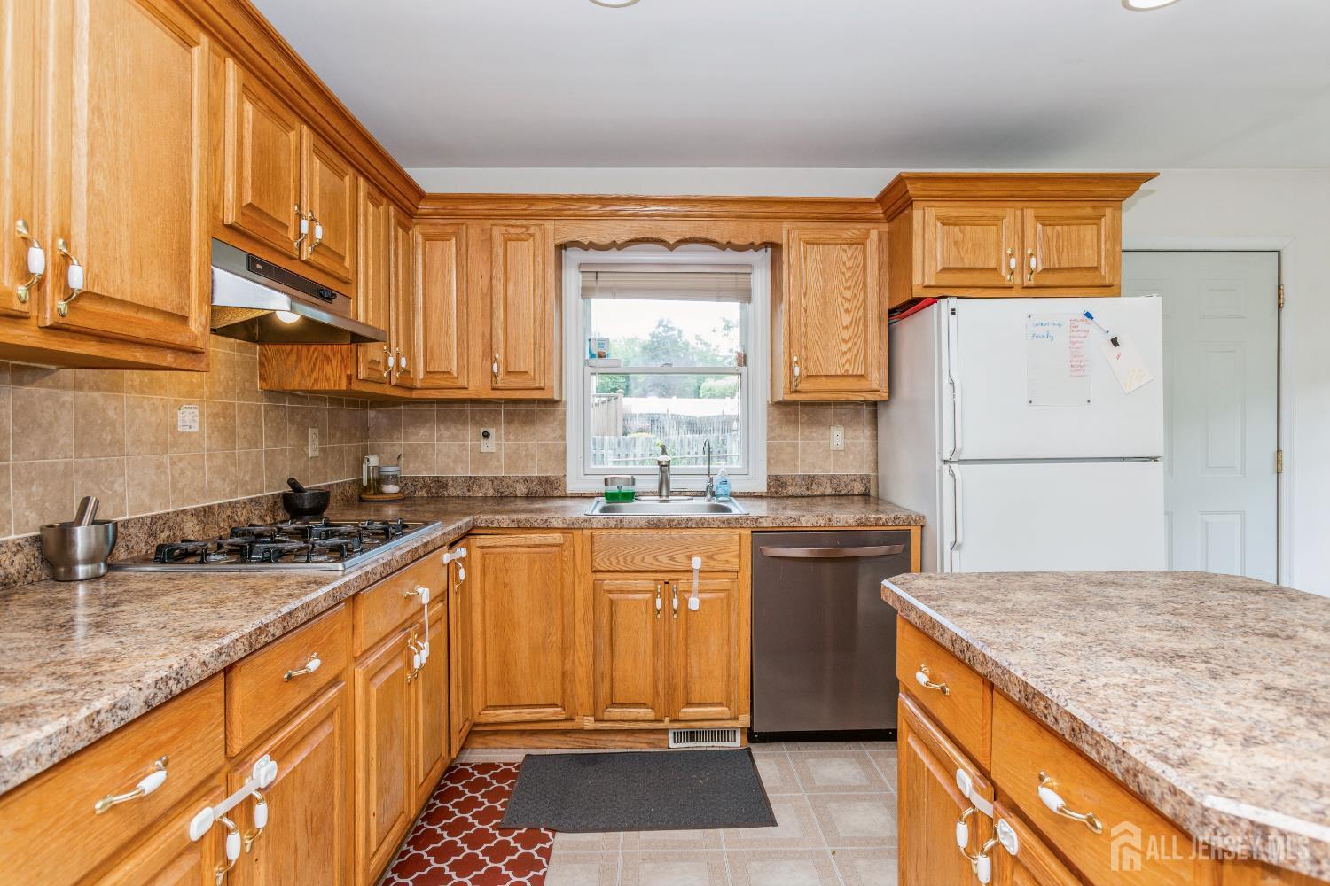 8 Longfellow Drive Colonia, NJ 07067 - Photo 7 of 24 a kitchen with a sink stove and refrigerator