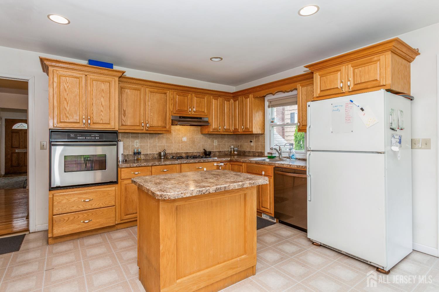 8 Longfellow Drive Colonia, NJ 07067 - Photo 9 of 24 a kitchen with a sink a stove and a refrigerator