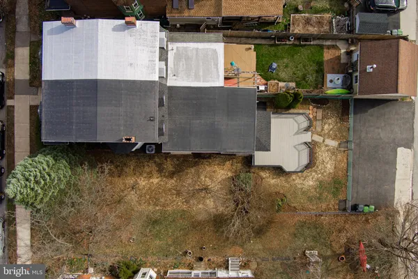 an aerial view of a house with a yard and large trees