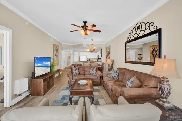 a living room with furniture a flat screen tv and a wall painting