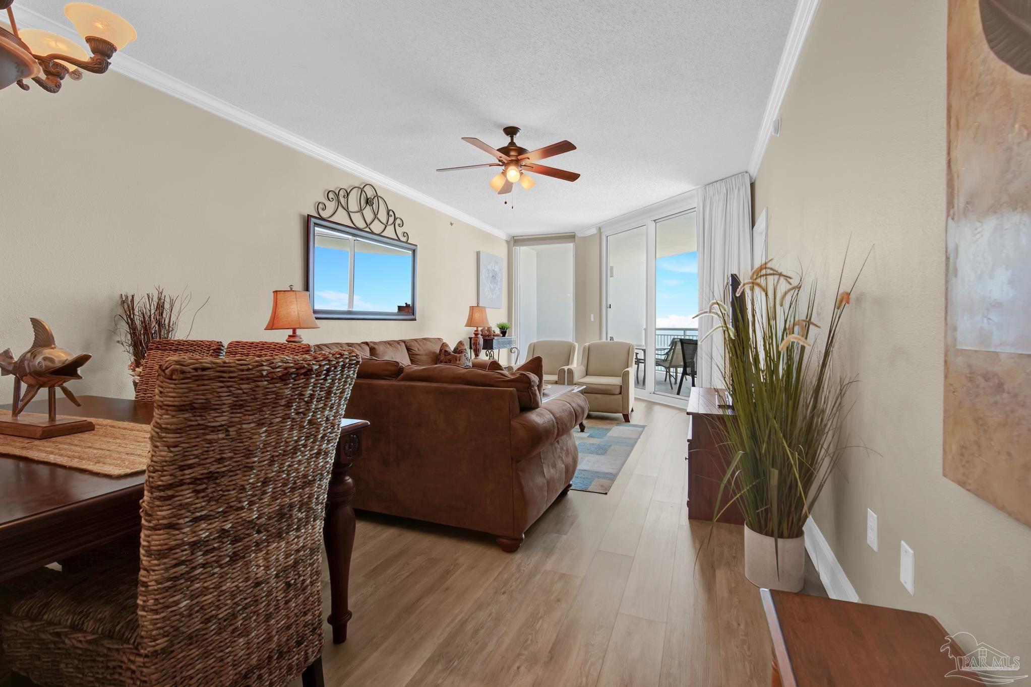 13661 Perdido Key Drive, Unit 1603 Perdido Key, FL 32507 - Photo 7 of 50 a living room with furniture a wooden floor and a chandelier