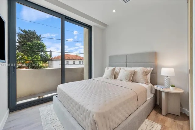 a large bed sitting in a bedroom next to a window