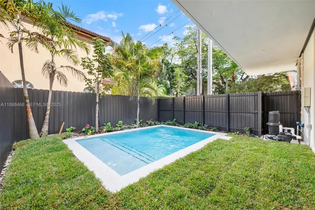 a view of a backyard with table and chairs and wooden fence