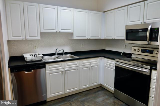 2151 Jamieson Avenue, Unit 411 Alexandria, VA 22314 - Photo 2 of 32 a kitchen with white cabinets and black appliances
