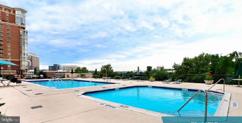 2151 Jamieson Avenue, Unit 411 Alexandria, VA 22314 - Photo 28 of 32 a view of a swimming pool with a lounge chairs