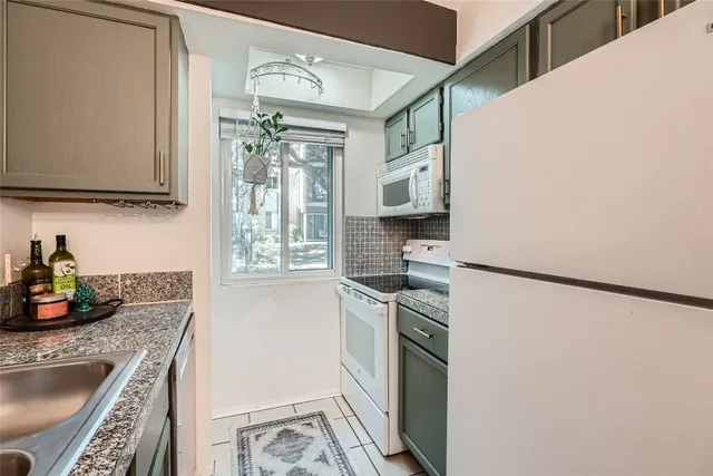 a kitchen with stainless steel appliances granite countertop a refrigerator sink and stove