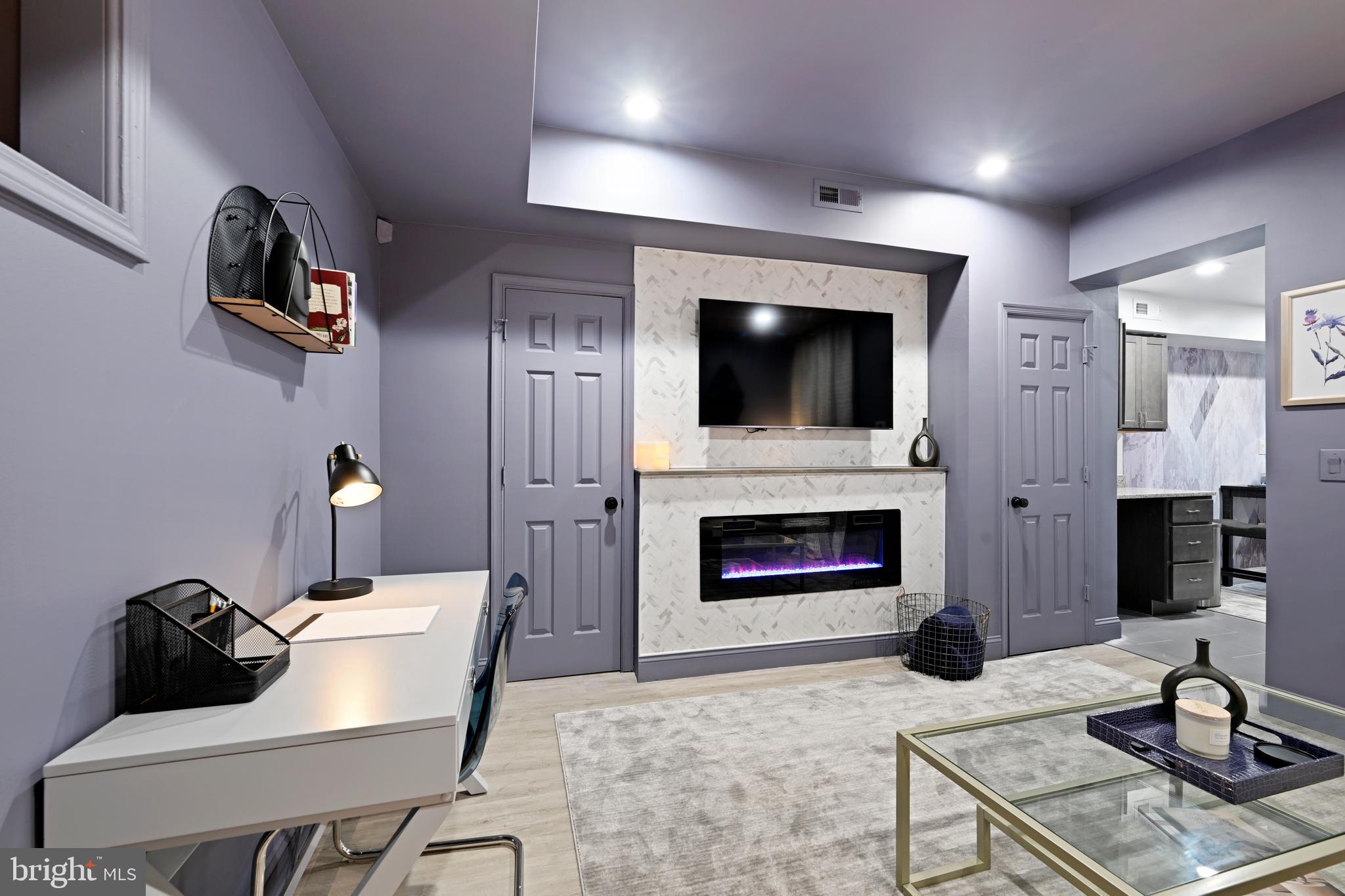 1709 Bank Street Baltimore, MD 21231 - Photo 27 of 49 a living room with furniture a fireplace and a flat screen tv