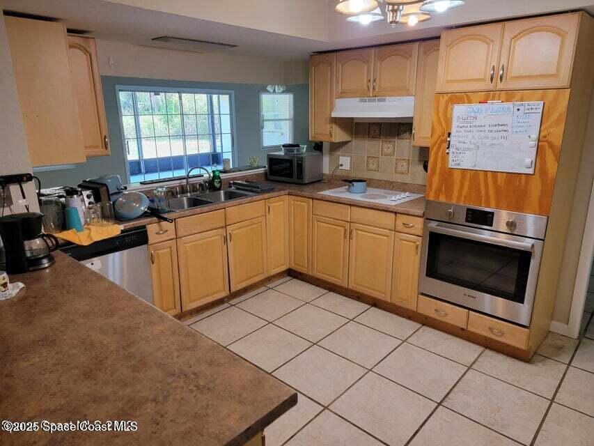 200 Southgate Boulevard Melbourne, FL 32901 - Photo 2 of 9 a kitchen with stainless steel appliances granite countertop a stove a sink and a microwave