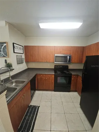 a kitchen with granite countertop a stove and a sink