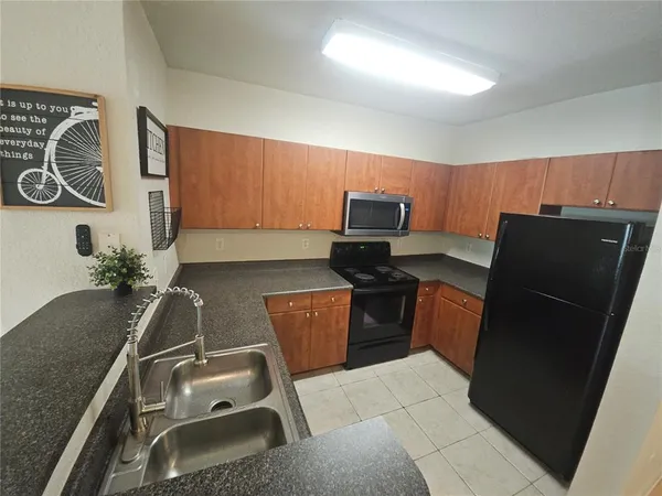 a kitchen with a refrigerator and a stove top oven