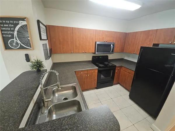 a kitchen with a sink a stove top oven and cabinetry