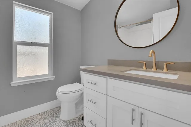 a bathroom with a toilet a sink and a mirror