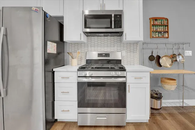 a kitchen with stainless steel appliances a stove microwave and refrigerator