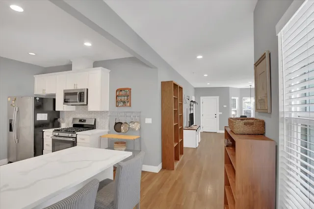 a kitchen with stainless steel appliances kitchen island granite countertop a refrigerator and a sink