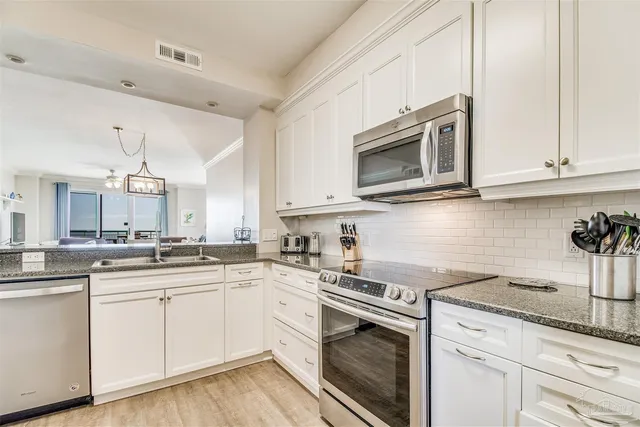 a kitchen with granite countertop white cabinets and white appliances